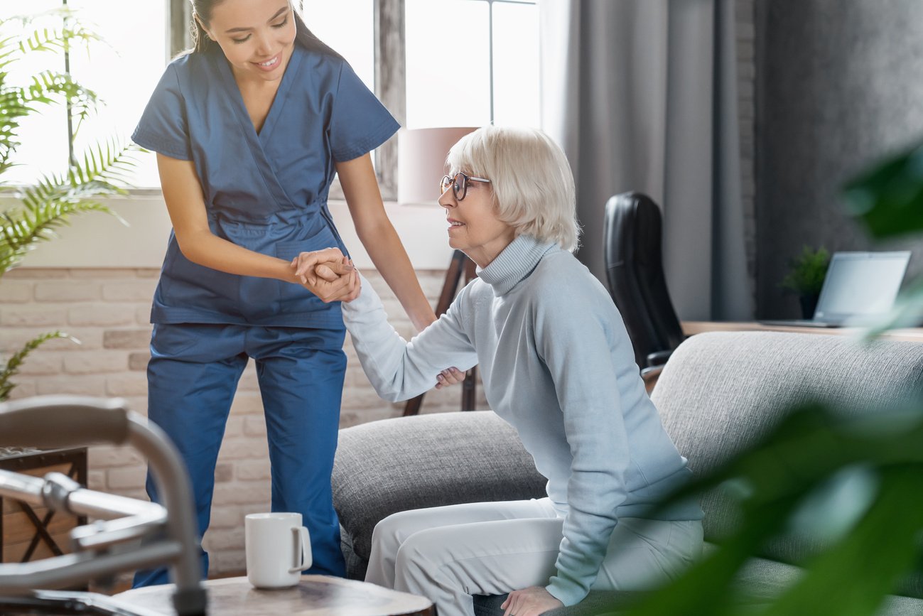 Professional caregiver taking care of elderly woman at home